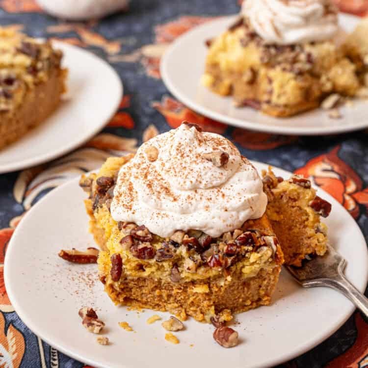 Homemade whipped cream on top of a serving of pumpkin dump cake.