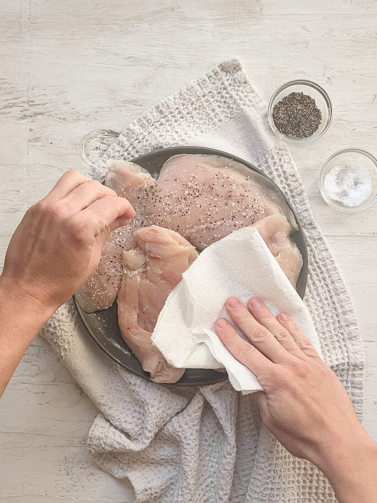 A paper towel removing moisture from chicken cutlets.