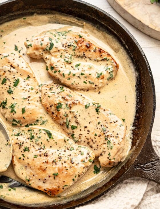Chicken cutlets smothered in Boursin gravy in a cast iron skillet.