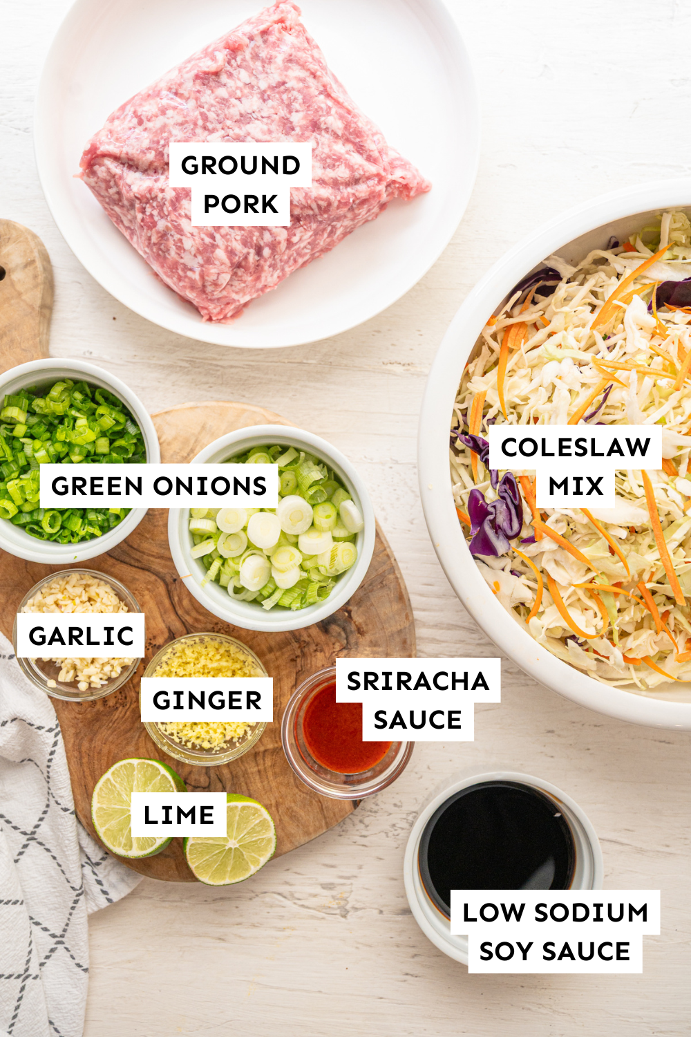 ingredients such as coleslaw, ground pork, soy sauce, and more for egg roll bowls in white bowls.
