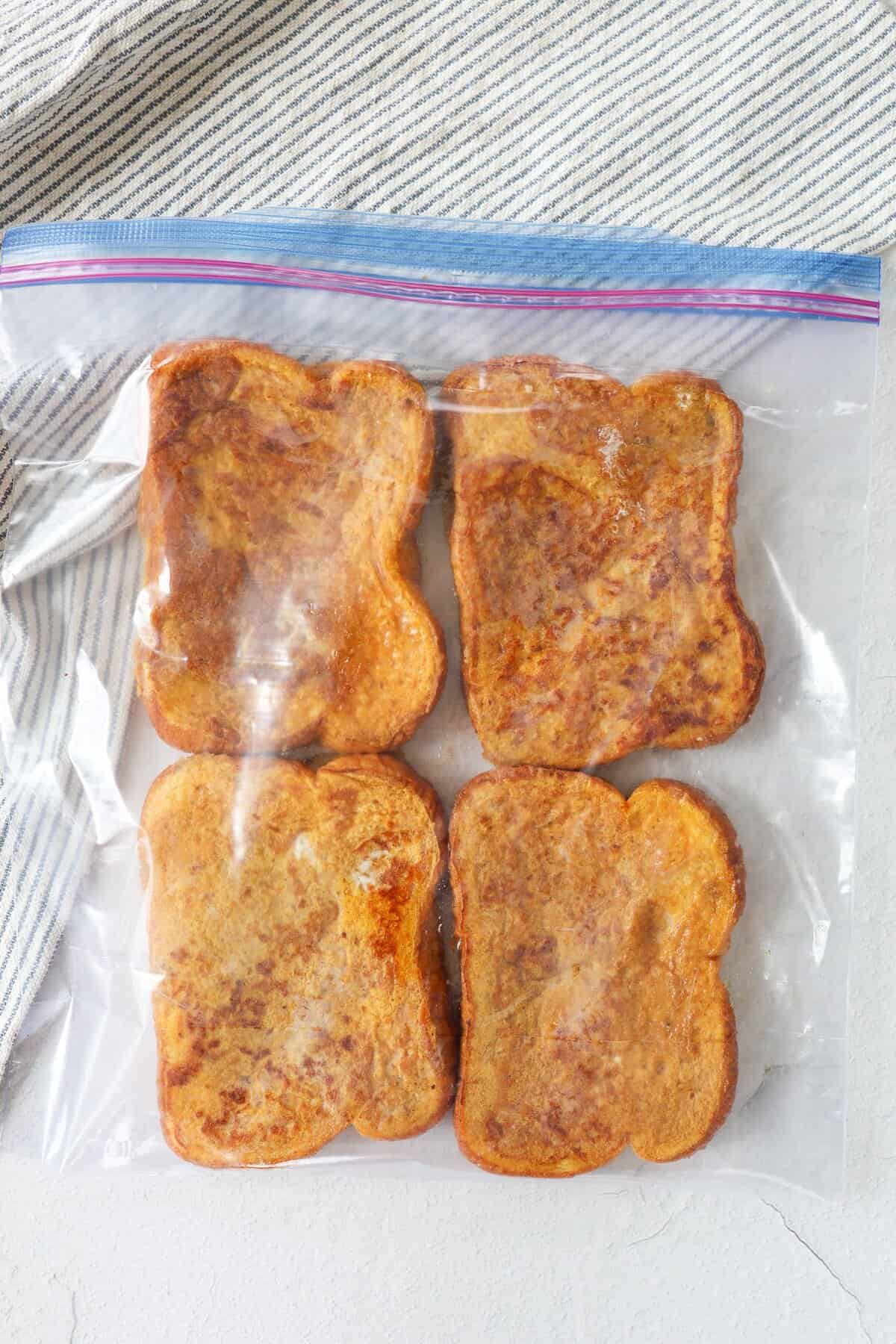 Pumpkin french toast slices in a single layer in a freezer-safe bag.