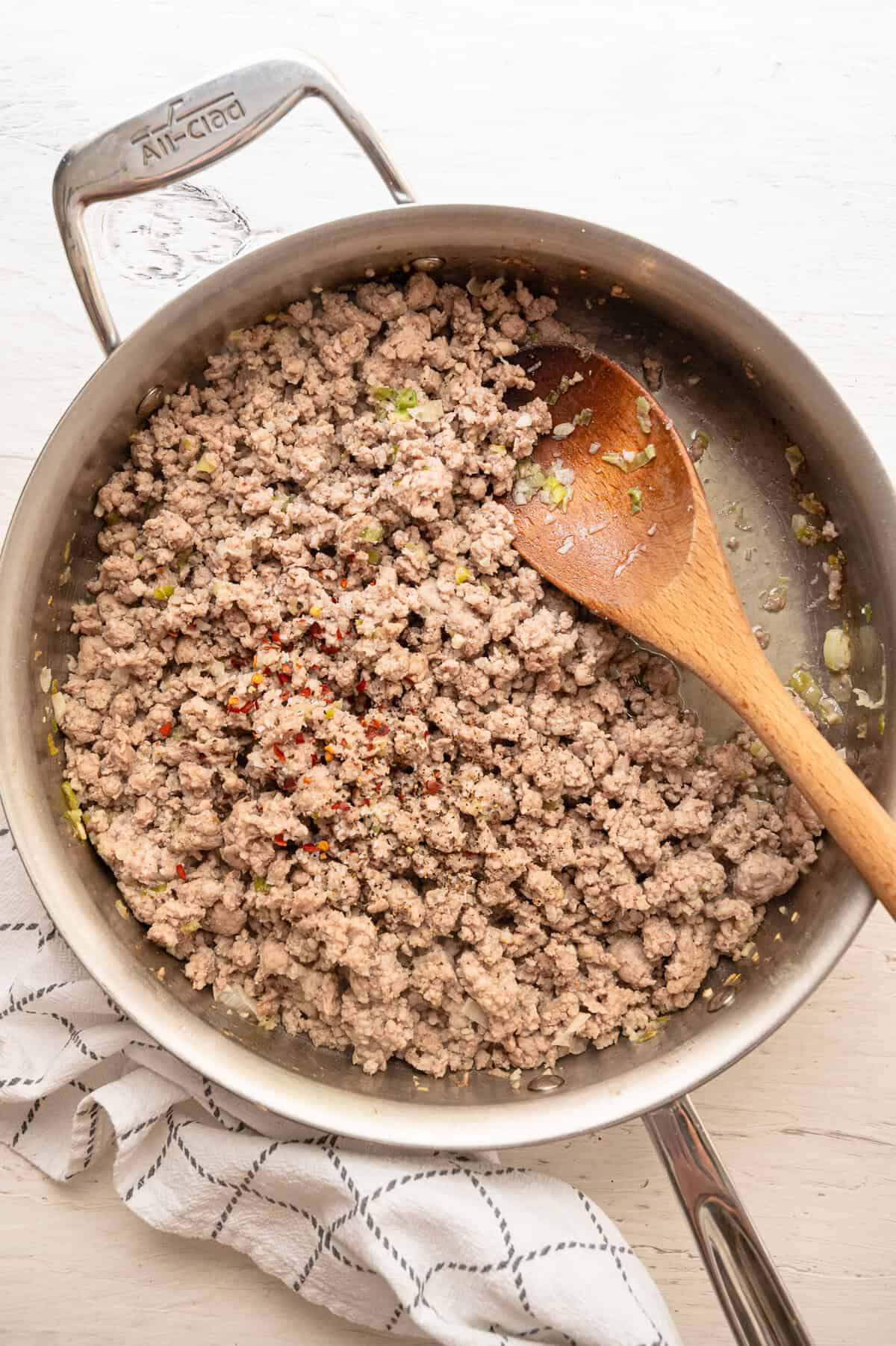 Ground pork and seasonings being sauteed in a skillet.