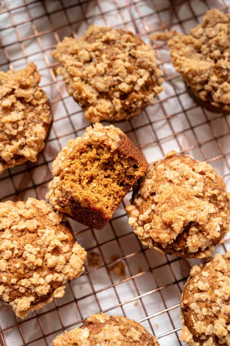 Pumpkin spice muffins with crumble topping on a cooling rack.