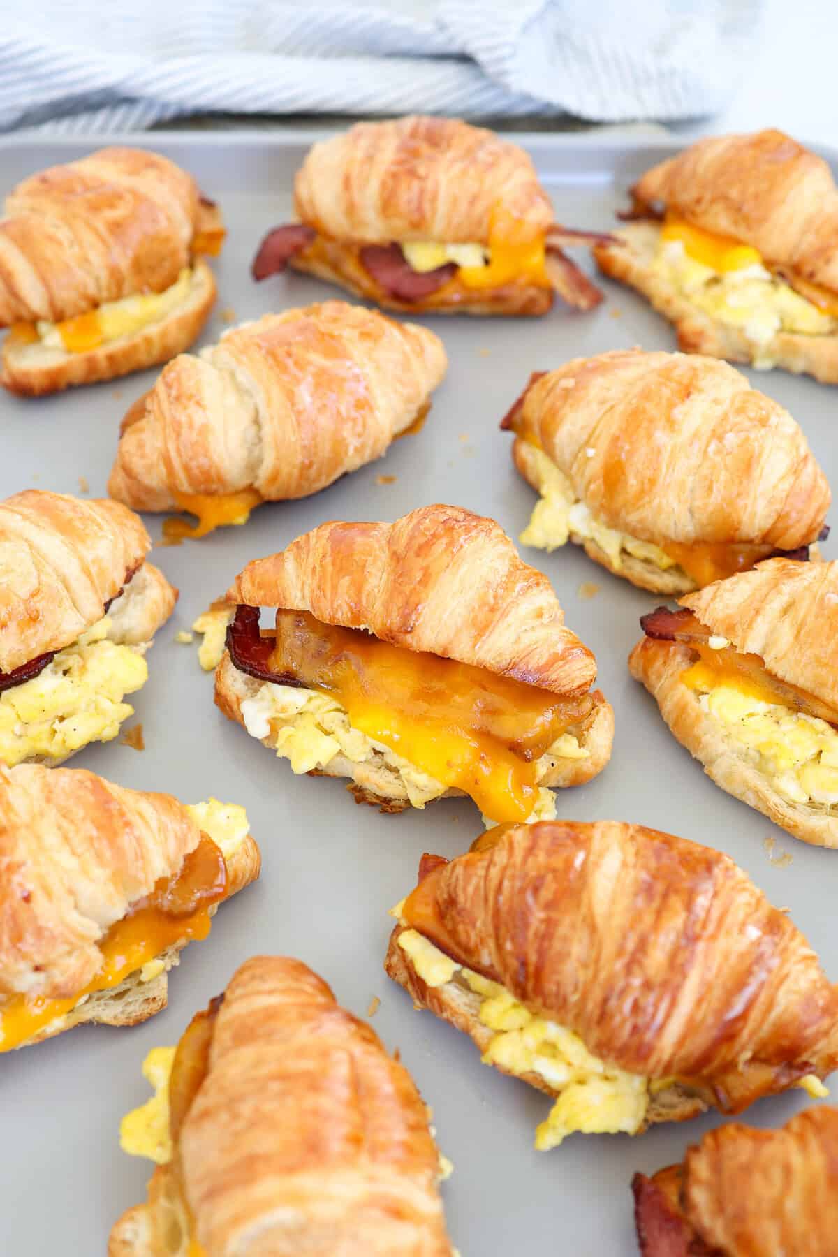 A baking sheet of croissant breakfast sandwiches straight from the oven.