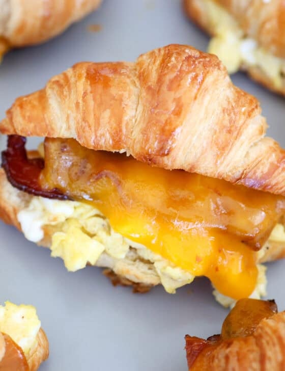 A baking sheet straight from the oven with croissant breakfast sandwiches.
