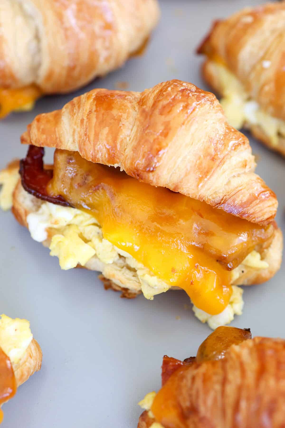 Bacon, scrambled eggs, and melted cheddar cheese on a split croissant and toasted.
