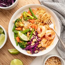 A shrimp curry bowl with chopped peanuts on top.