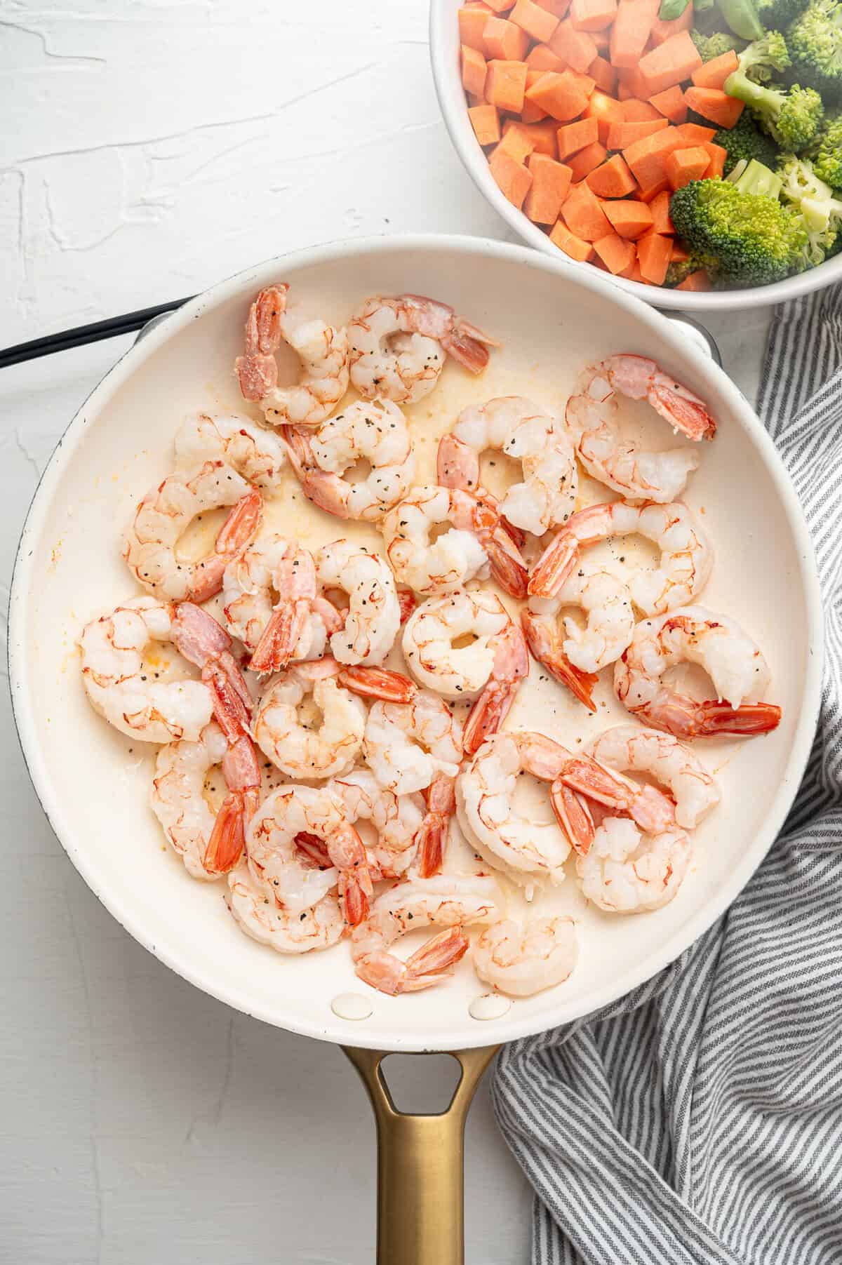 Shrimp sauteing in a skillet.