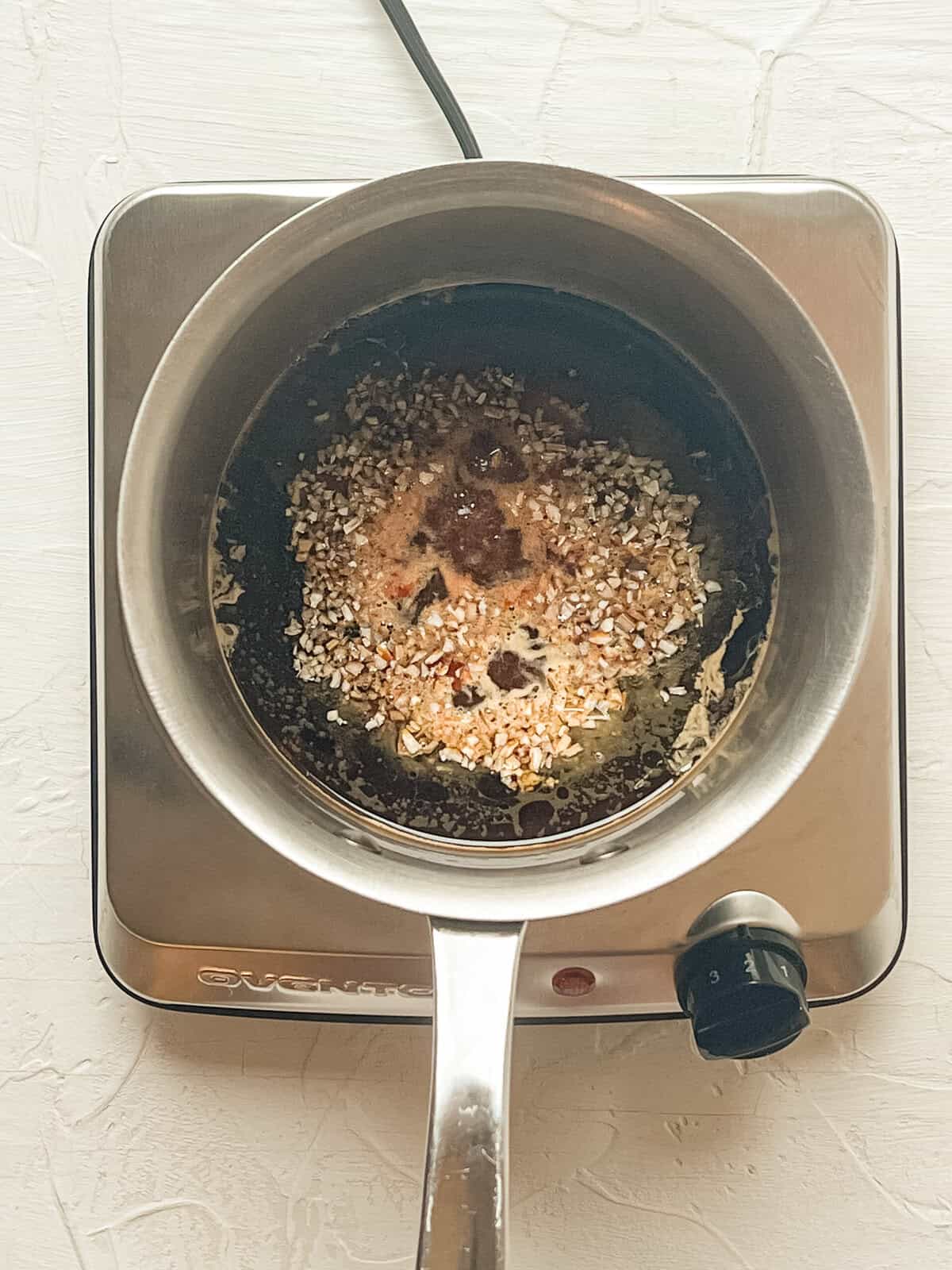 A sauce pan cooking ingredients for sweet soy sauce.