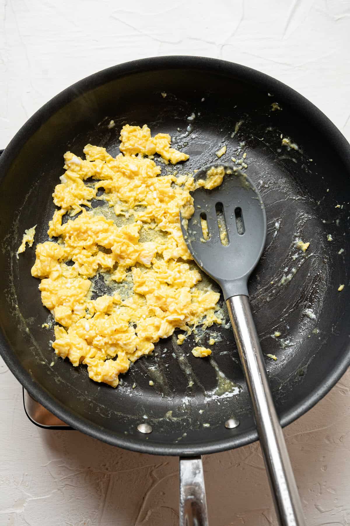 Eggs being scrambled in a skillet.