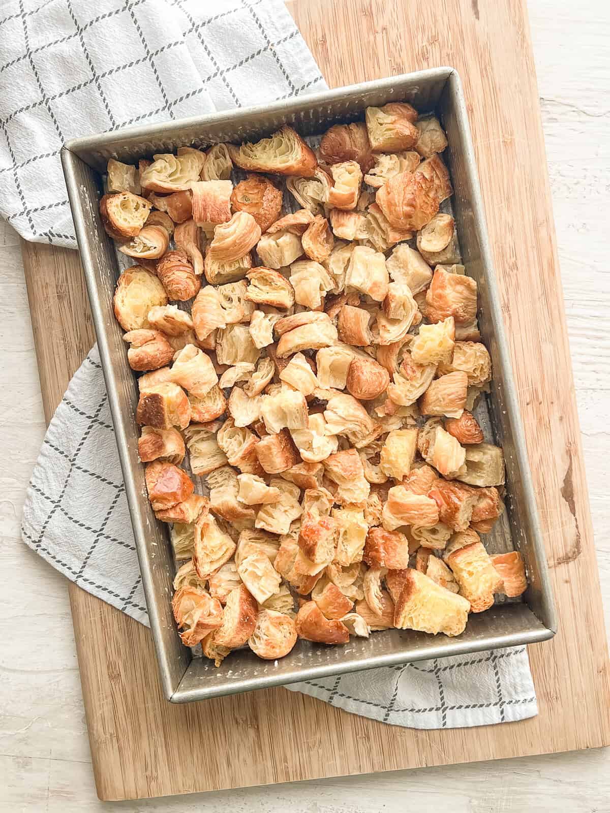 Cubes of toasted croissants layered in a 9x12 pan.