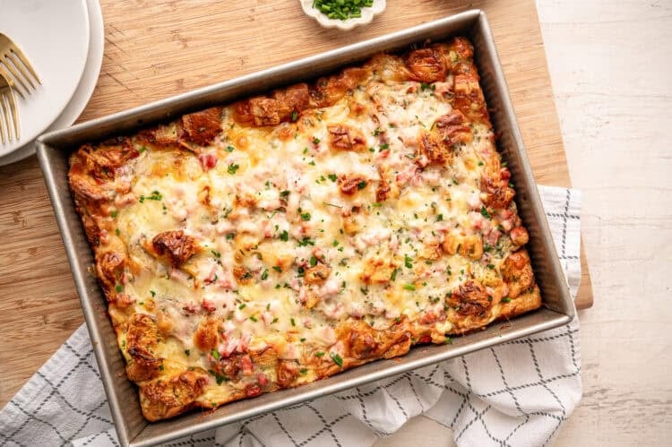 Croissant breakfast casserole with chopped fresh herbs on top ready to serve.