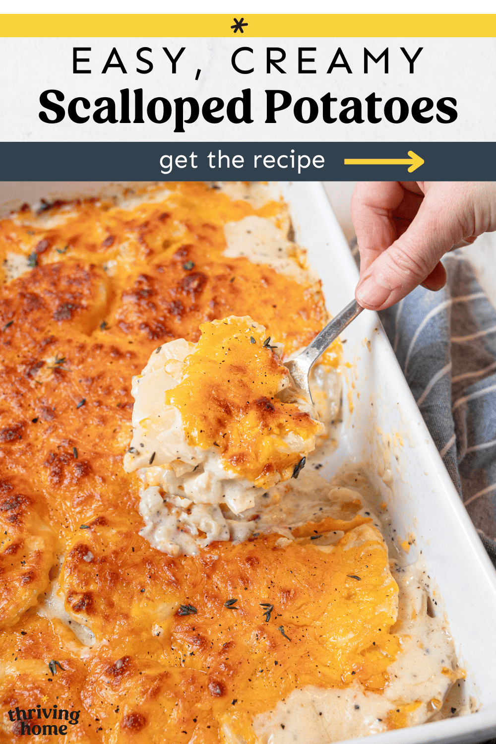 A scoop of scalloped potatoes being served from a 9x12 casserole dish.