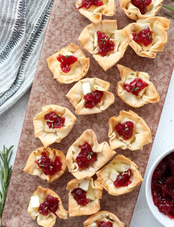 A marble platter of mini brie and cranberry phyllo cups.