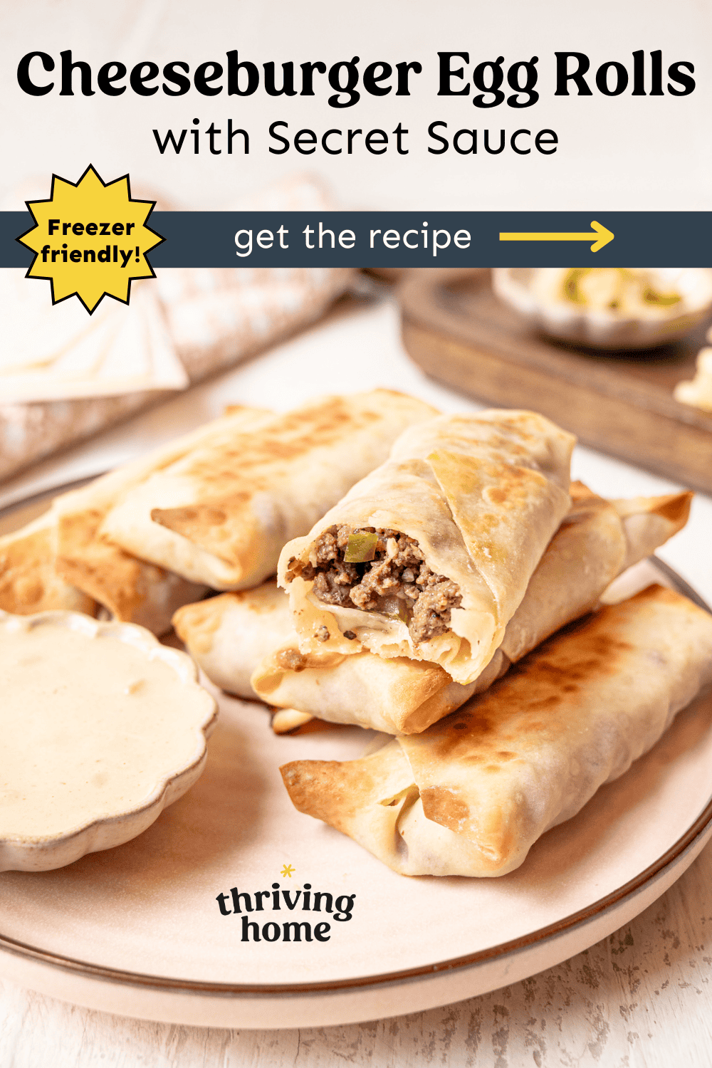 Cheeseburger egg rolls stacked on a plate next to a bowl of secret dipping sauce.