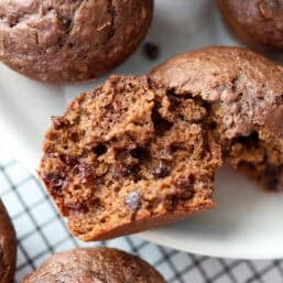 Two halves of a chocolate banana muffin on a plate.