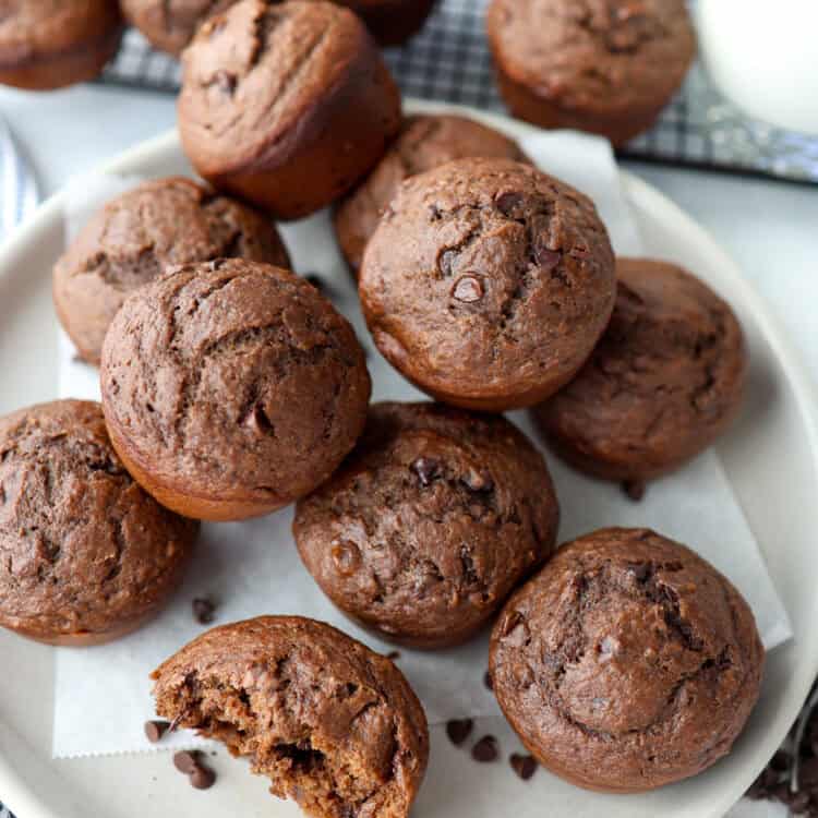Chocolate banana muffins piled on a plate.