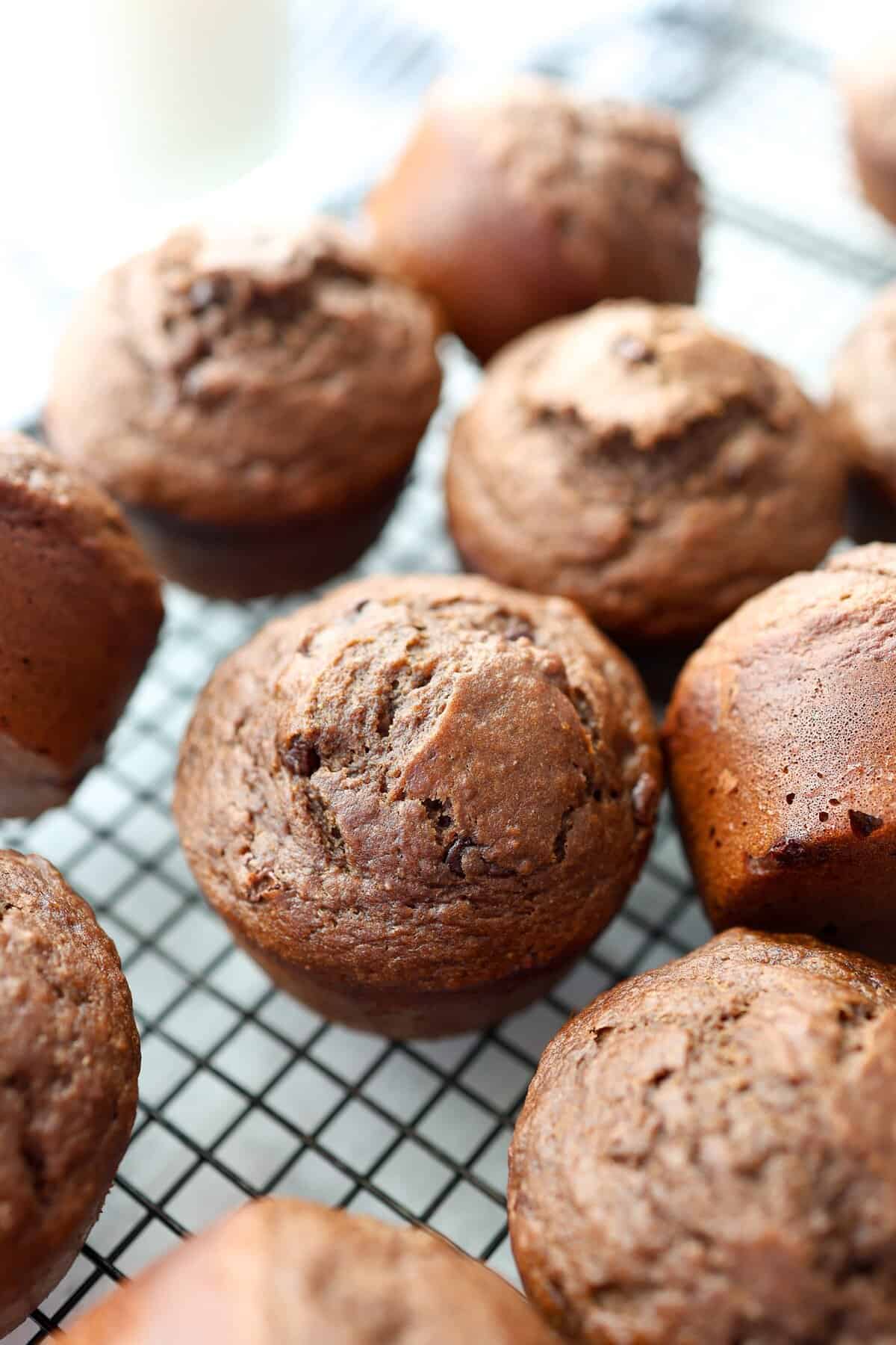 Chocolate banana muffins cooling on a baking rack.