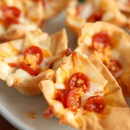 A close up of a pepperoni pizza mini phyllo cup showing melted cheese and mini pepperonis.