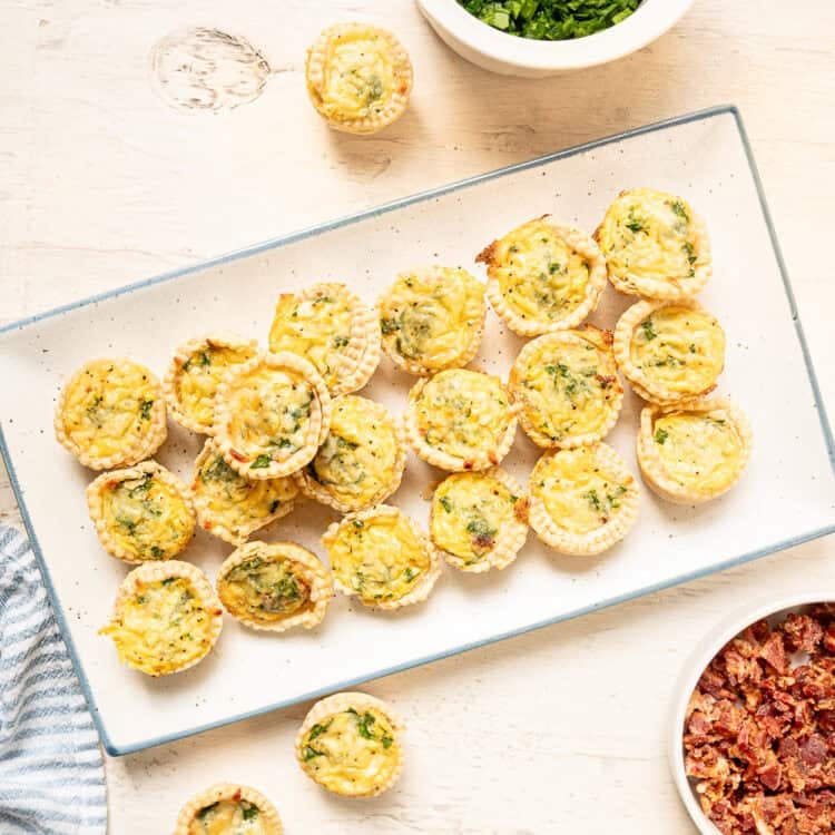 A platter of spinach and bacon mini quiche ready to serve.