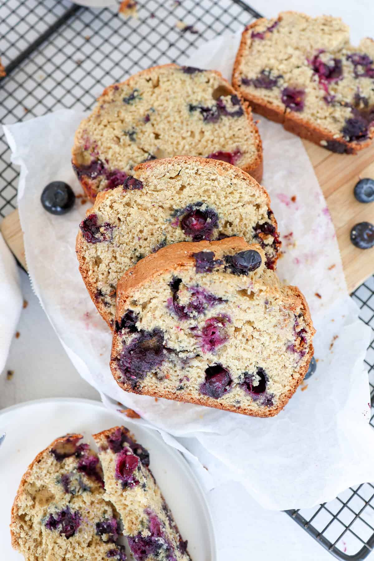 Slices of blueberry banana bread on parchment paper.