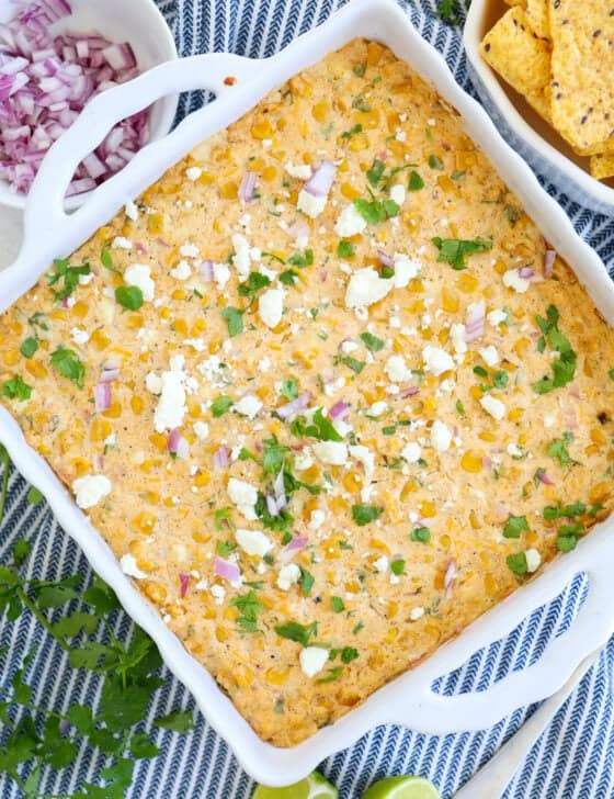 Mexican street corn dip out of the oven with chopped cilantro and crumbled cotija cheese on top.