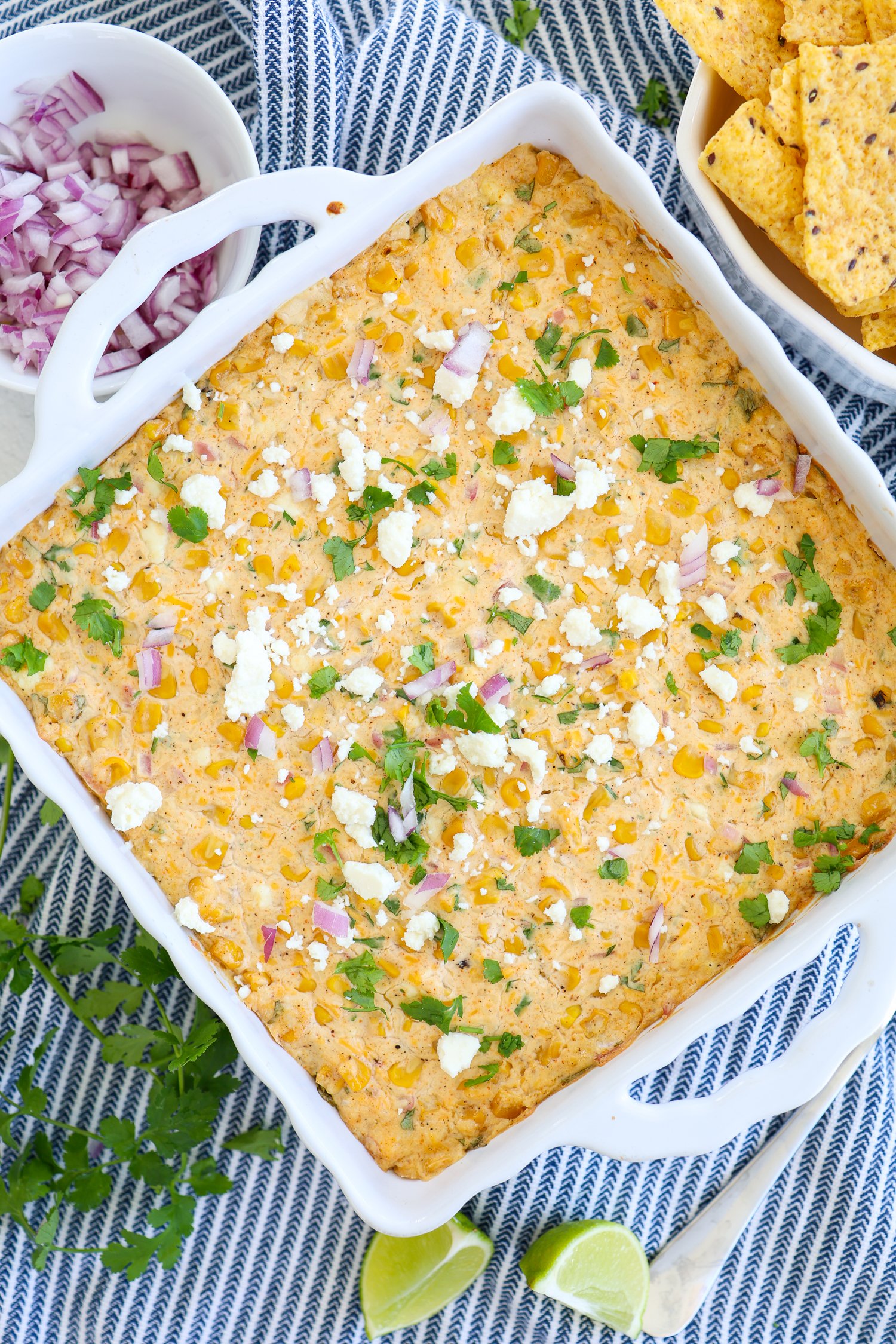 Mexican street corn dip out of the oven with chopped cilantro and crumbled cotija cheese on top.
