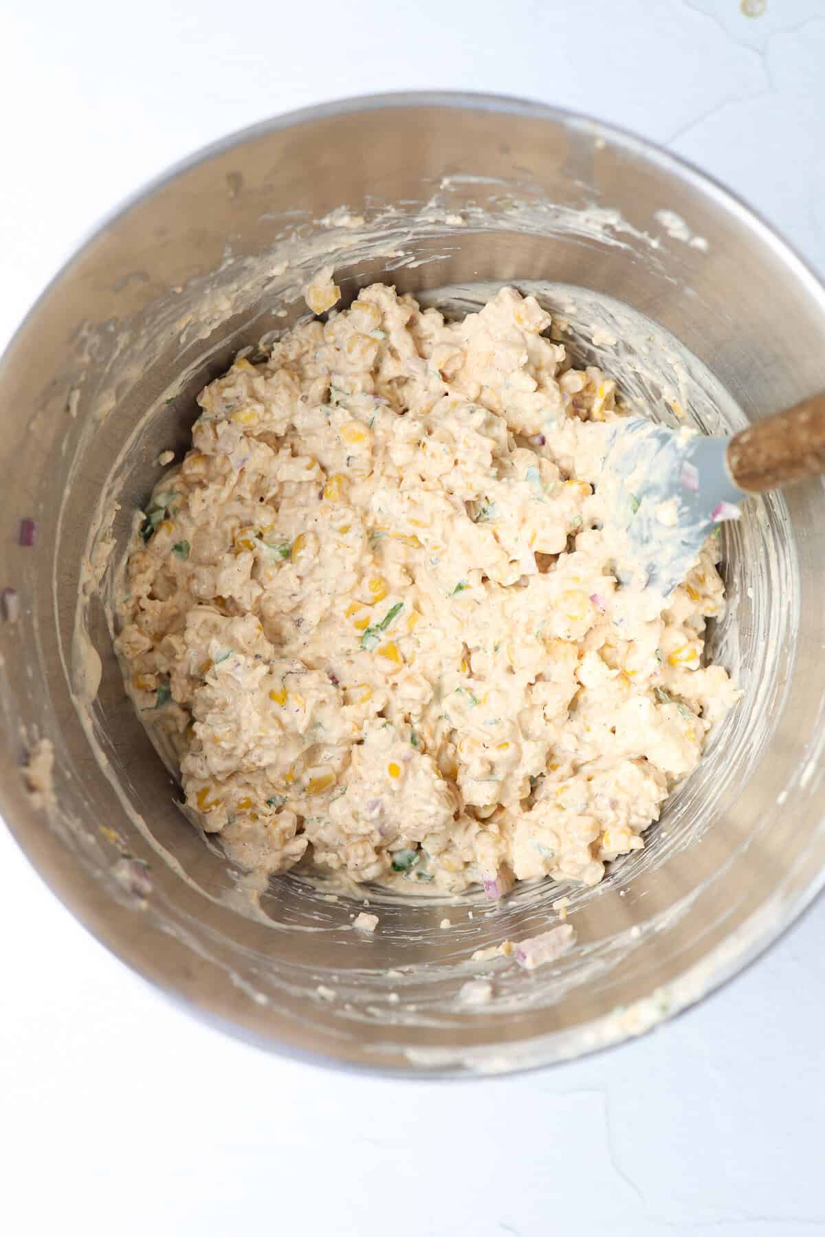 Ingredients for Mexican street corn dip mixed together in a mixing bowl.
