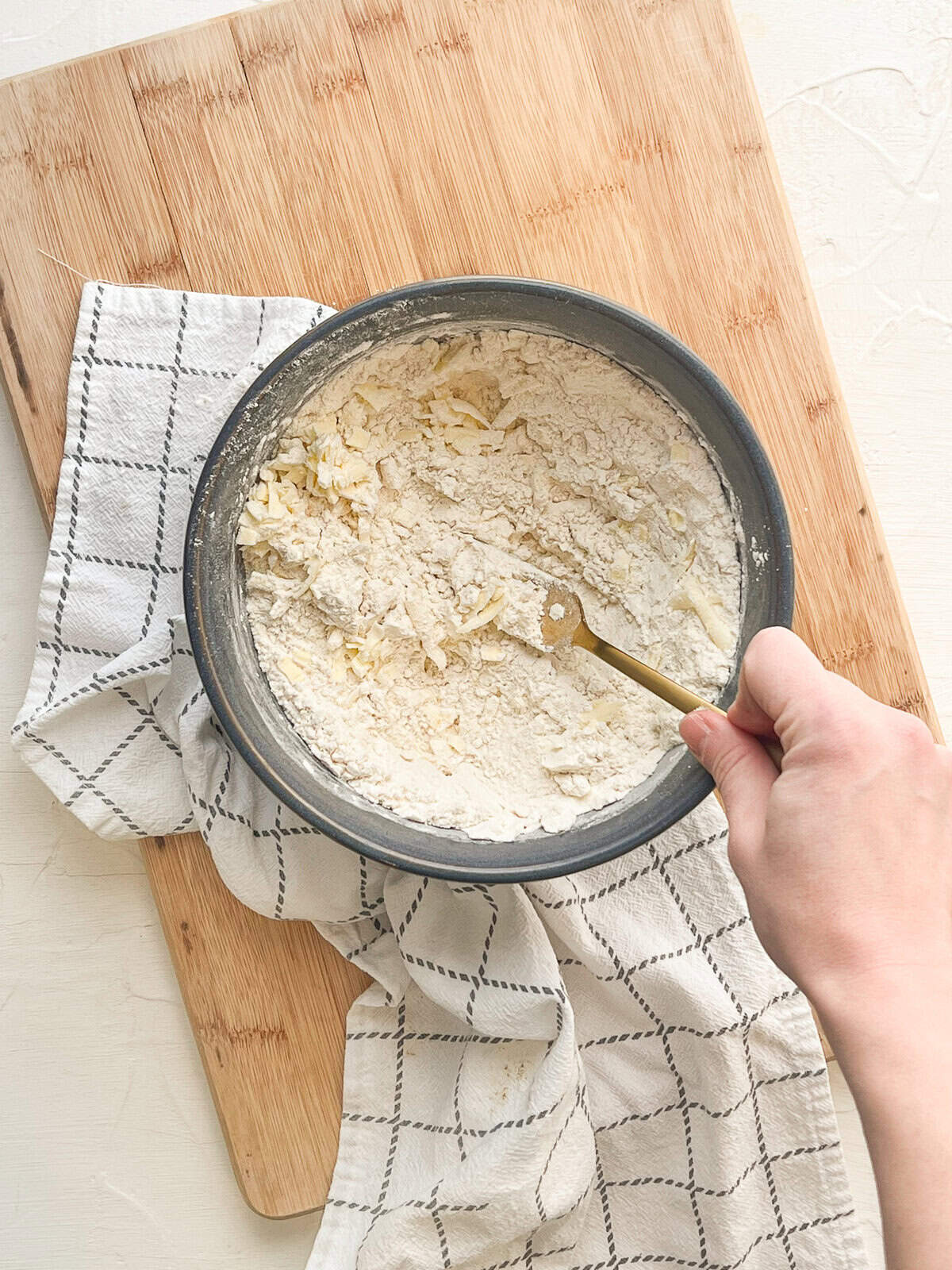 A fork cutting butter into dry ingredients for biscuits.