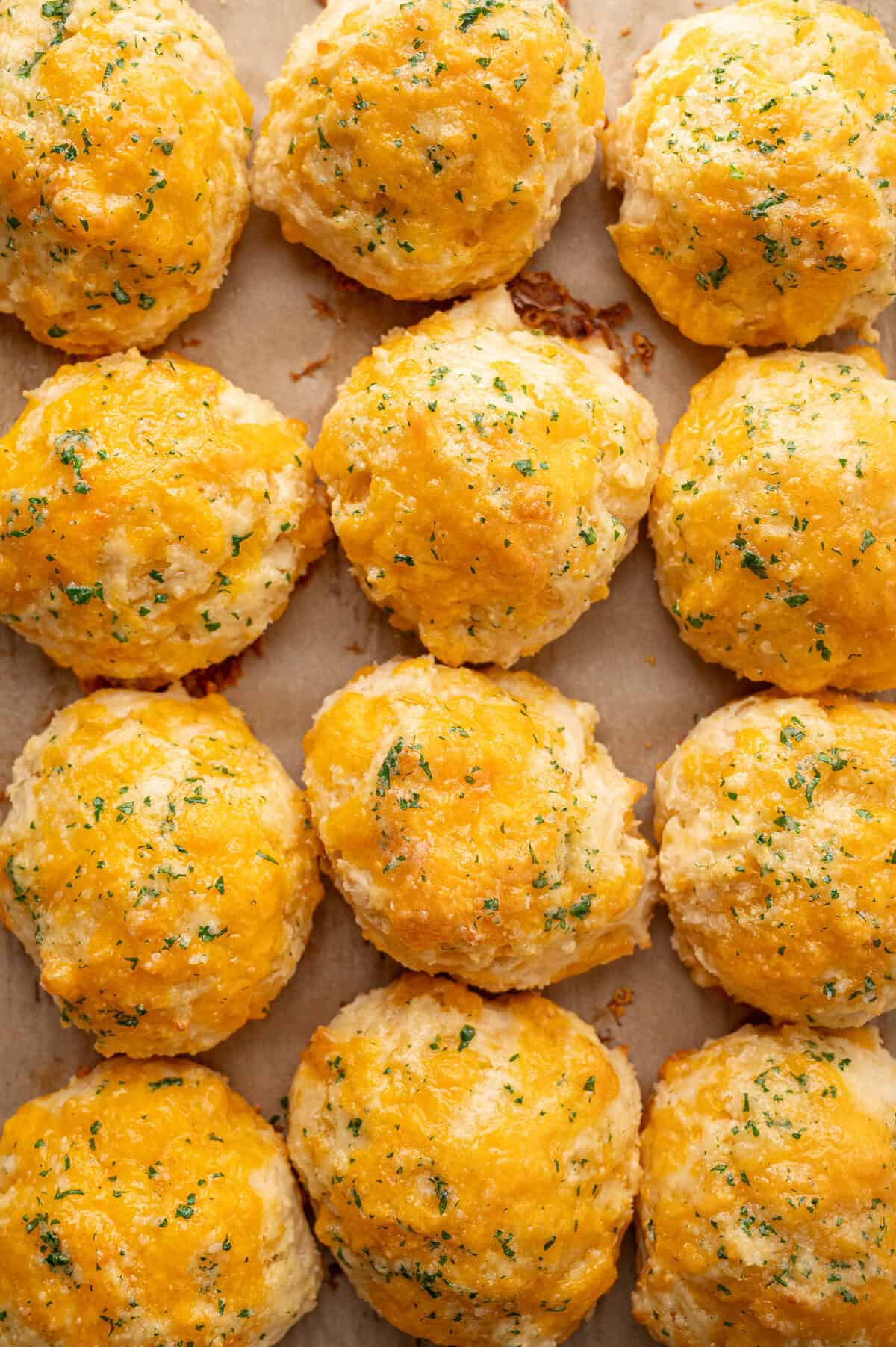 Cheddar biscuits topped with butter and fresh parsley straight from the oven.