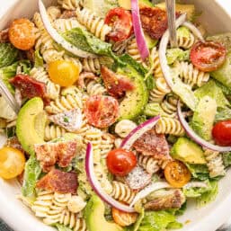 Cooke pasta, chopped lettuce, bacon, and cherry tomatoes, along with sliced avocado and red onion, mixed together with homemade ranch dressing.