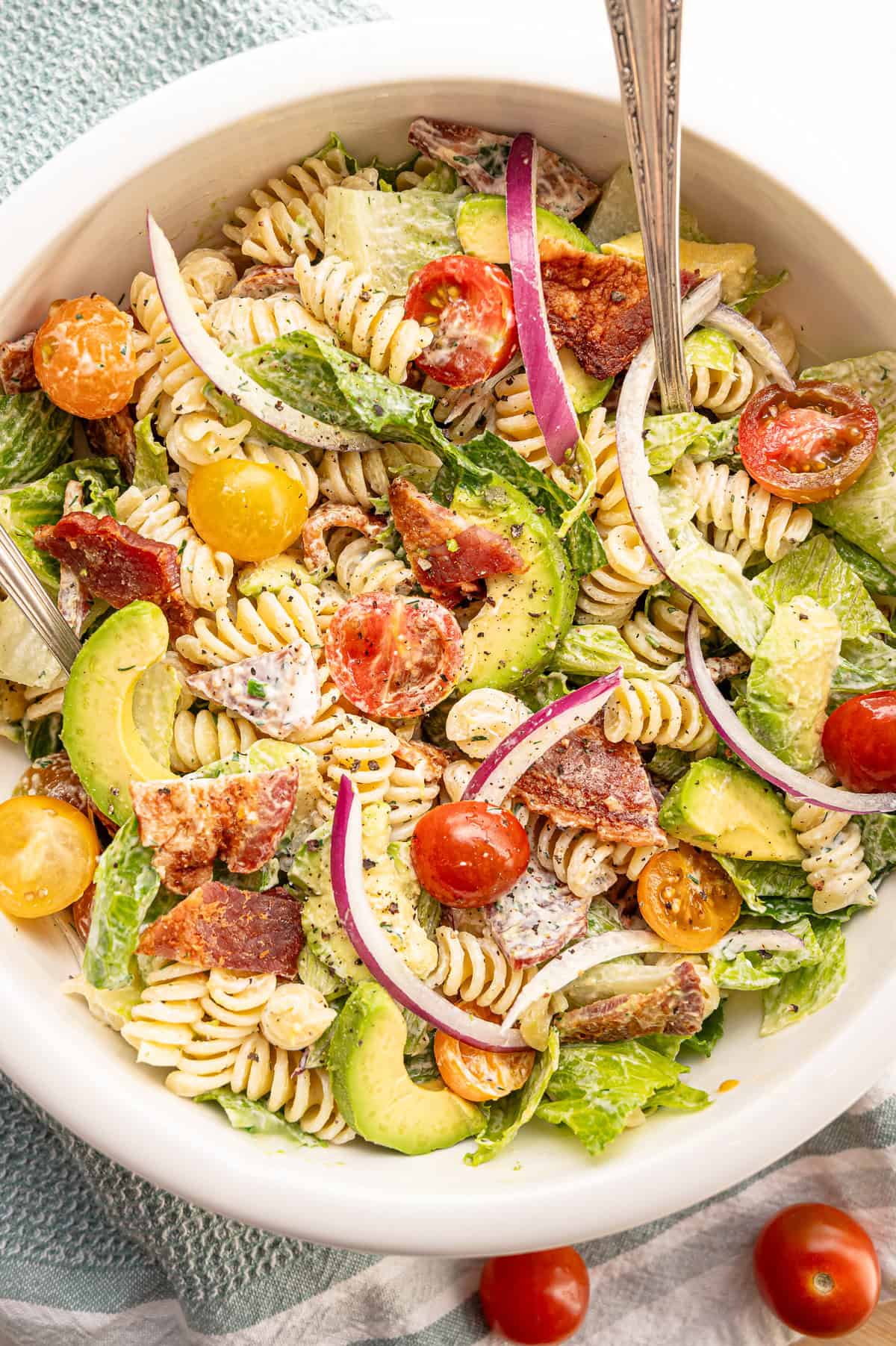 Cooke pasta, chopped lettuce, bacon, and cherry tomatoes, along with sliced avocado and red onion, mixed together with homemade ranch dressing.