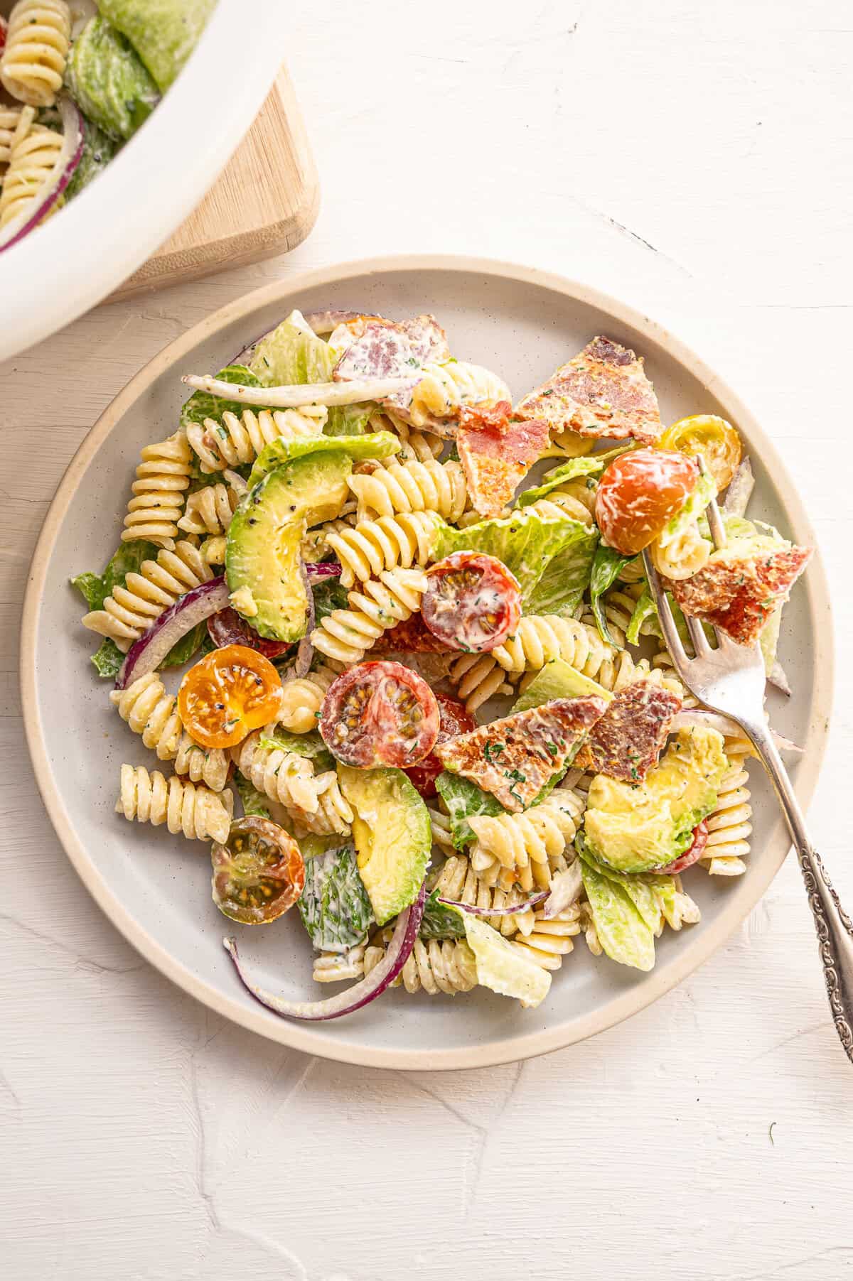 A side dish of BLT pasta salad on a white dish.