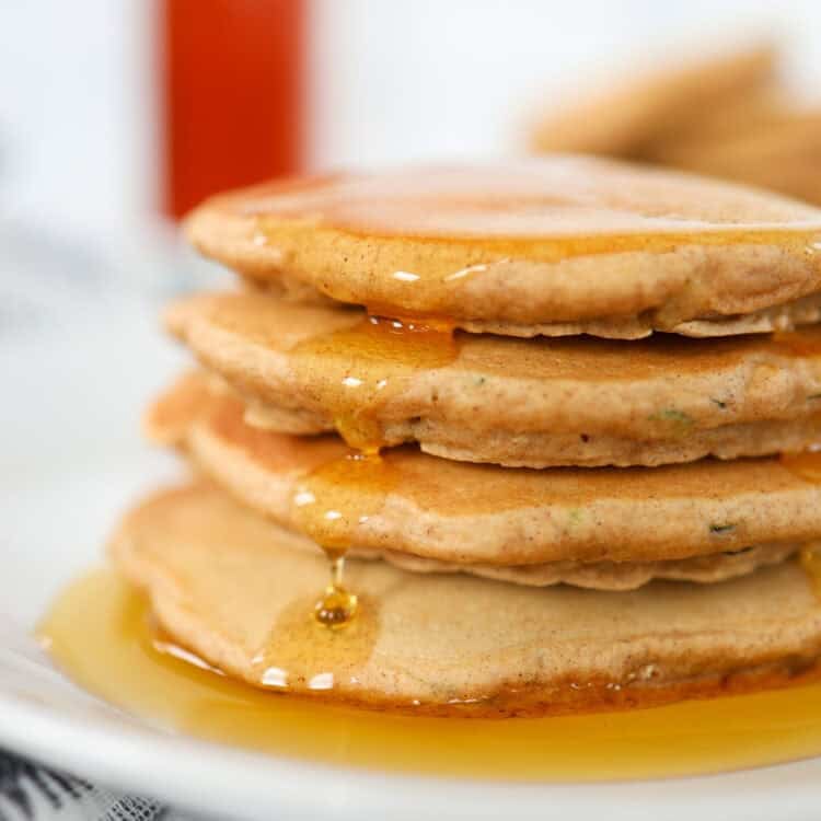 Maple syrup dripping down a stack of zucchini pancakes.