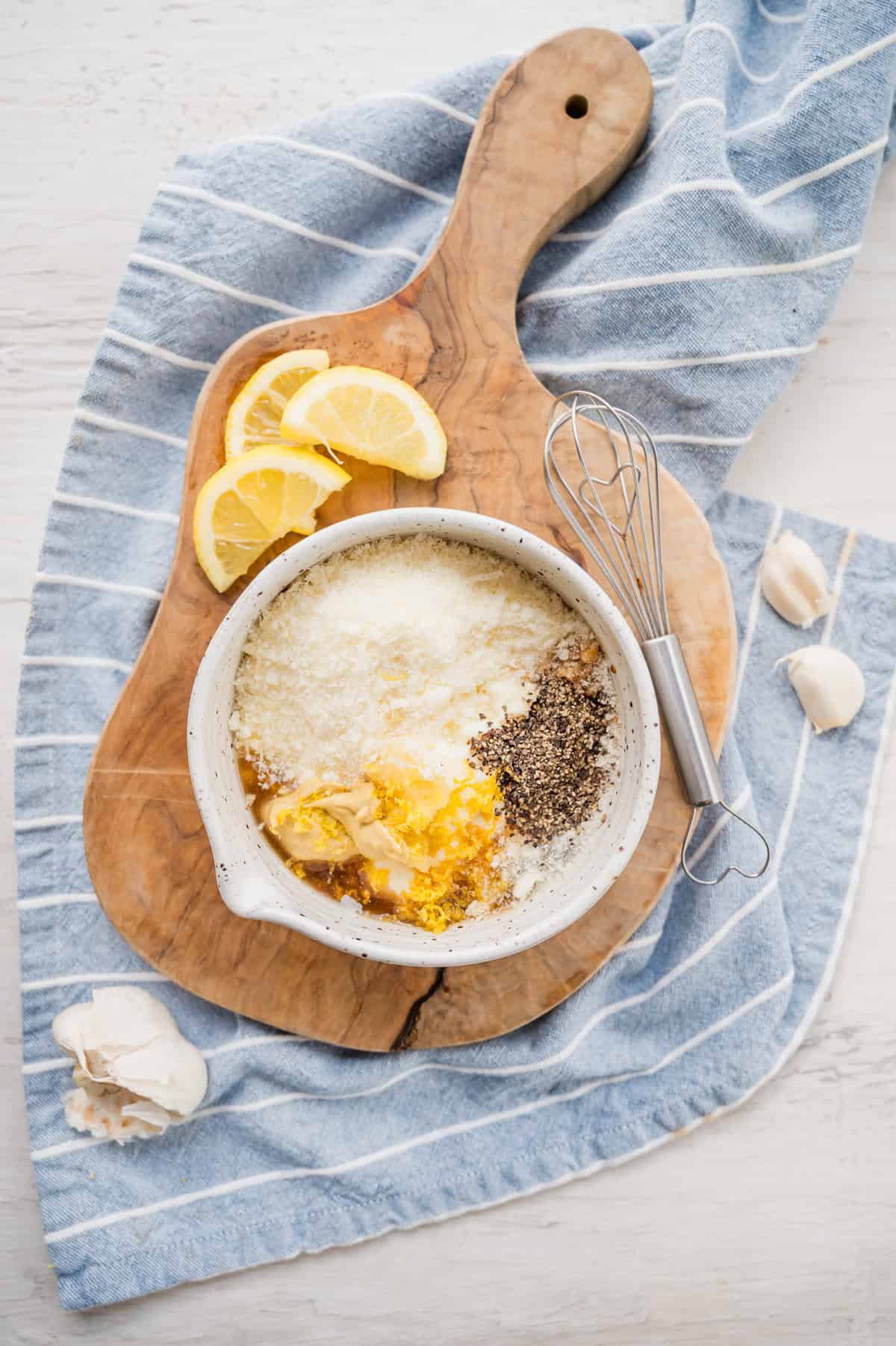 Caesar dressing ingredients in a bowl ready to be whisked together.