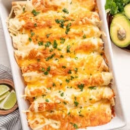 Fully cooked chicken fajita casserole in a white baking dish topped with parsley.