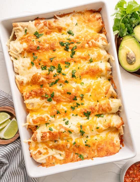 Fully cooked chicken fajita casserole in a white baking dish topped with parsley.