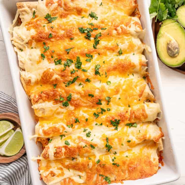 Fully cooked chicken fajita casserole in a white baking dish topped with parsley.