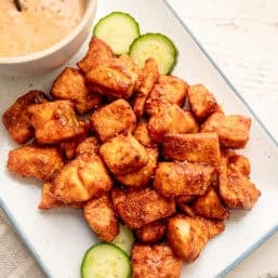 Salmon bites served on a platter with sesame seeds sprinkled on top.