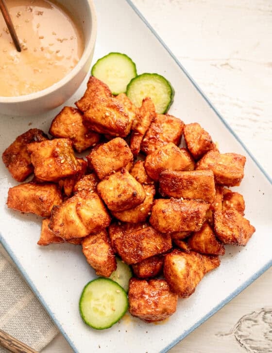 Salmon bites served on a platter with sesame seeds sprinkled on top.