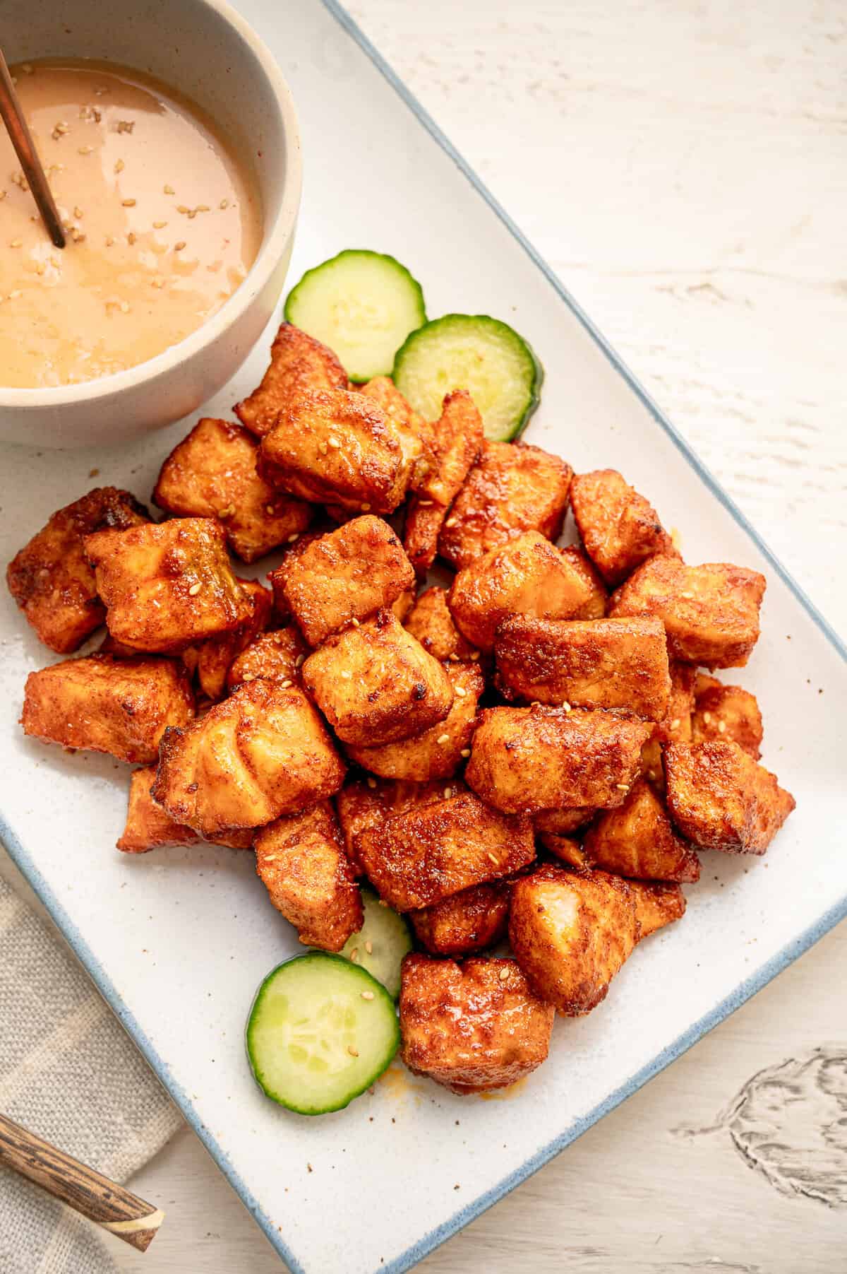 Salmon bites served on a platter with sesame seeds sprinkled on top.