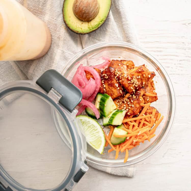 A container with salmon bang bang bowl ingredients prepped for lunches.
