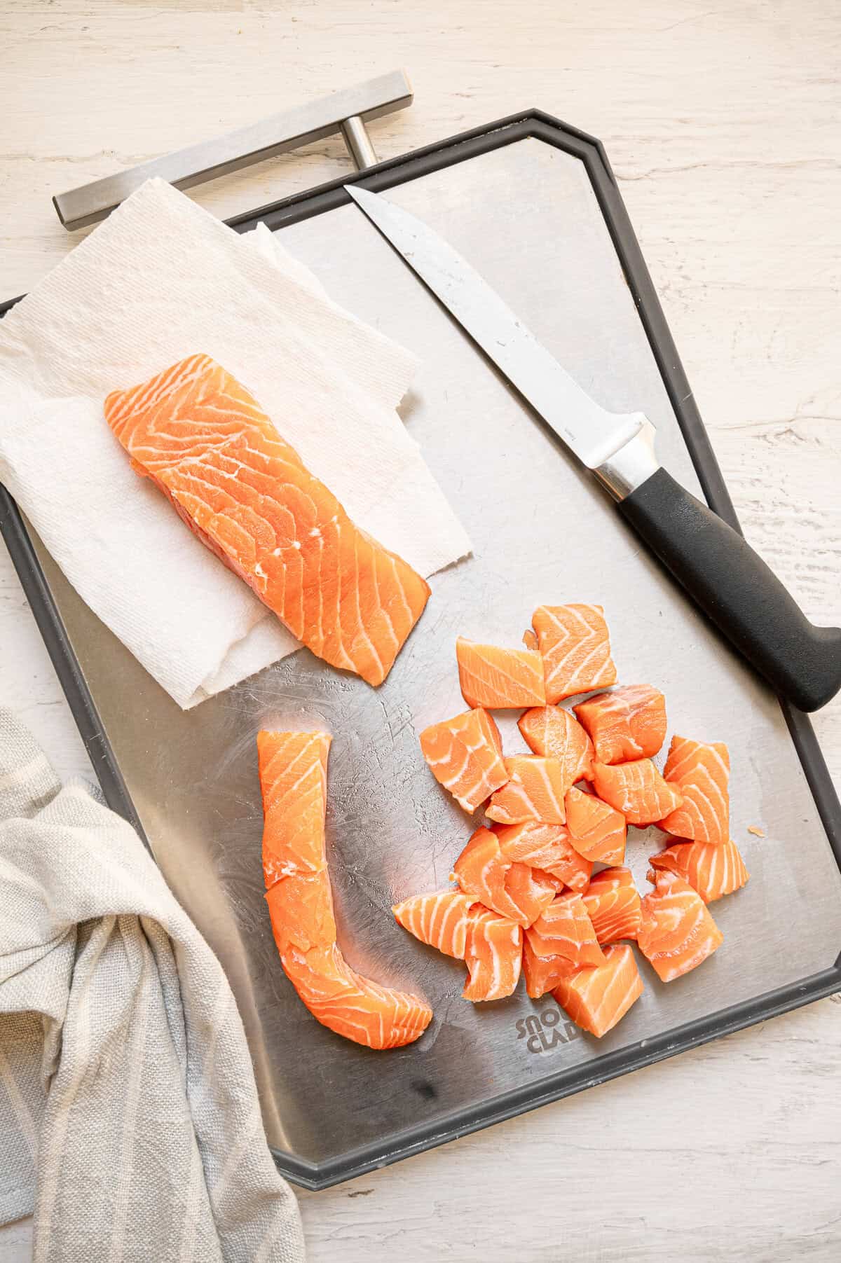 Salmon filets being cut into bite-sized pieces.