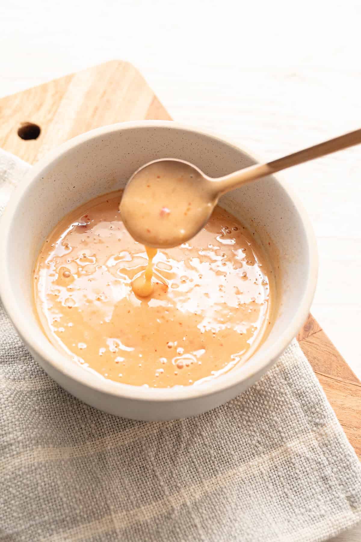 A small bowl with Bang Bang Sauce being spooned out.