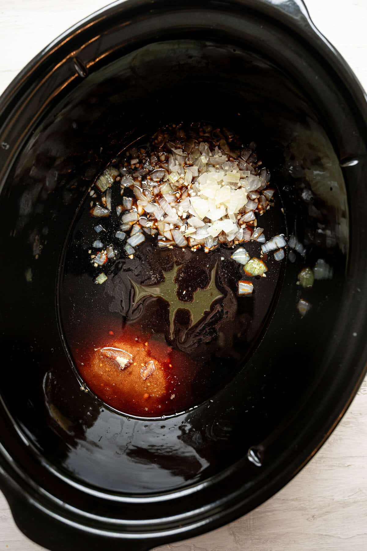 Ingredients for teriyaki chicken in a slow cooker waiting for the raw chicken thighs.