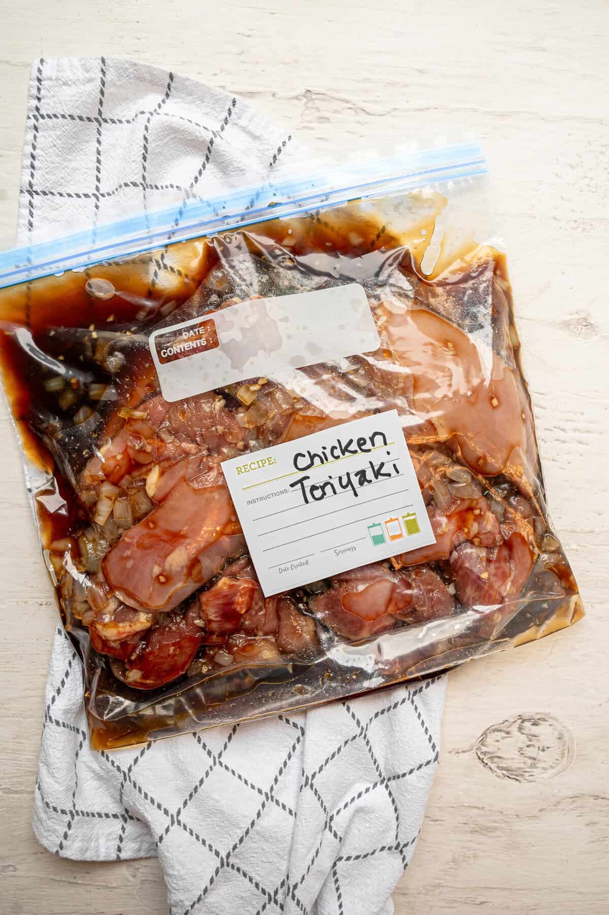 Boneless skinless chicken thighs in a freezer bag with teriyaki sauce ingredients.