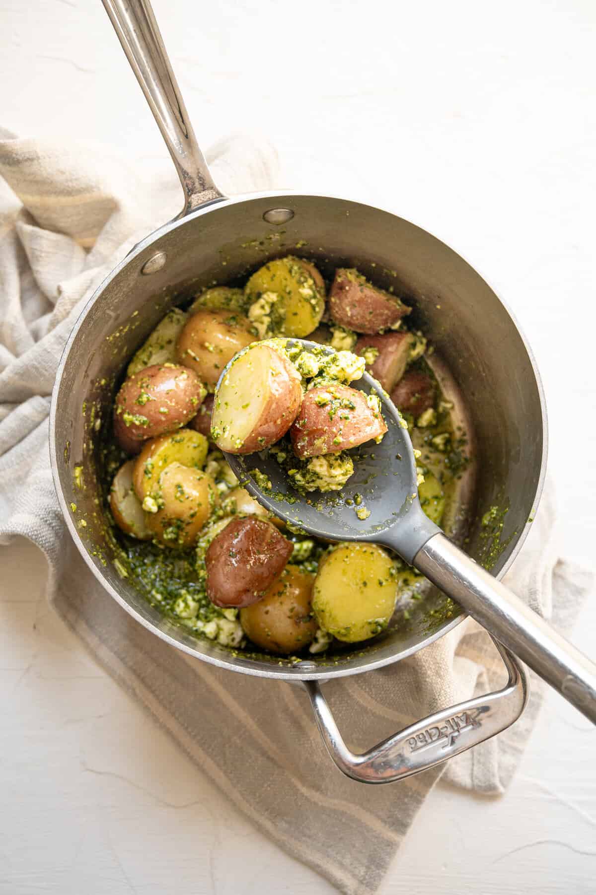 Pesto potato salad served from a saucepan.