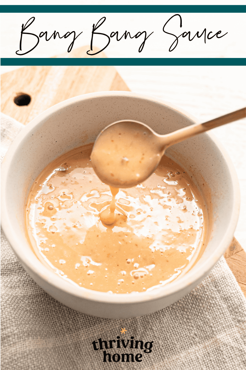 Small bowl of Bang Bang Sauce with a spoon heaping some out.