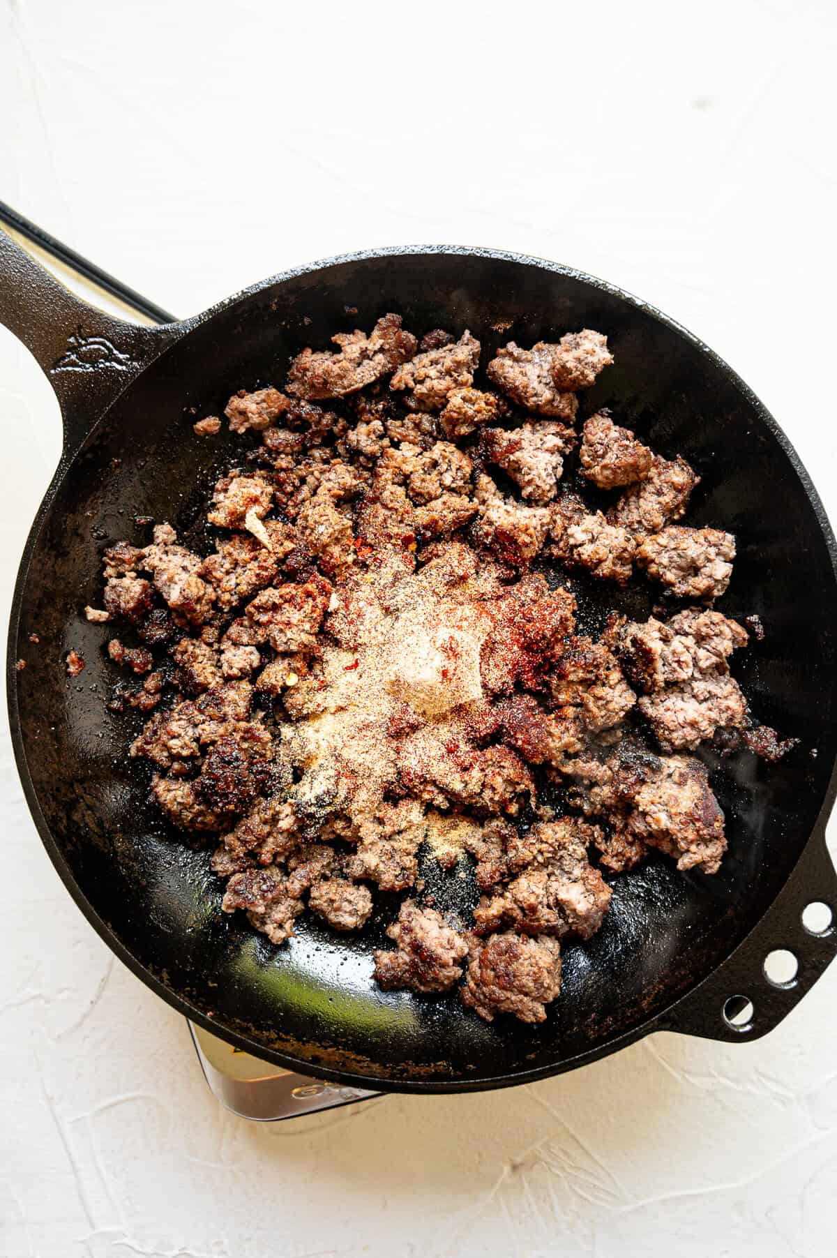 Ground beef sauteing in a cast iron skillet