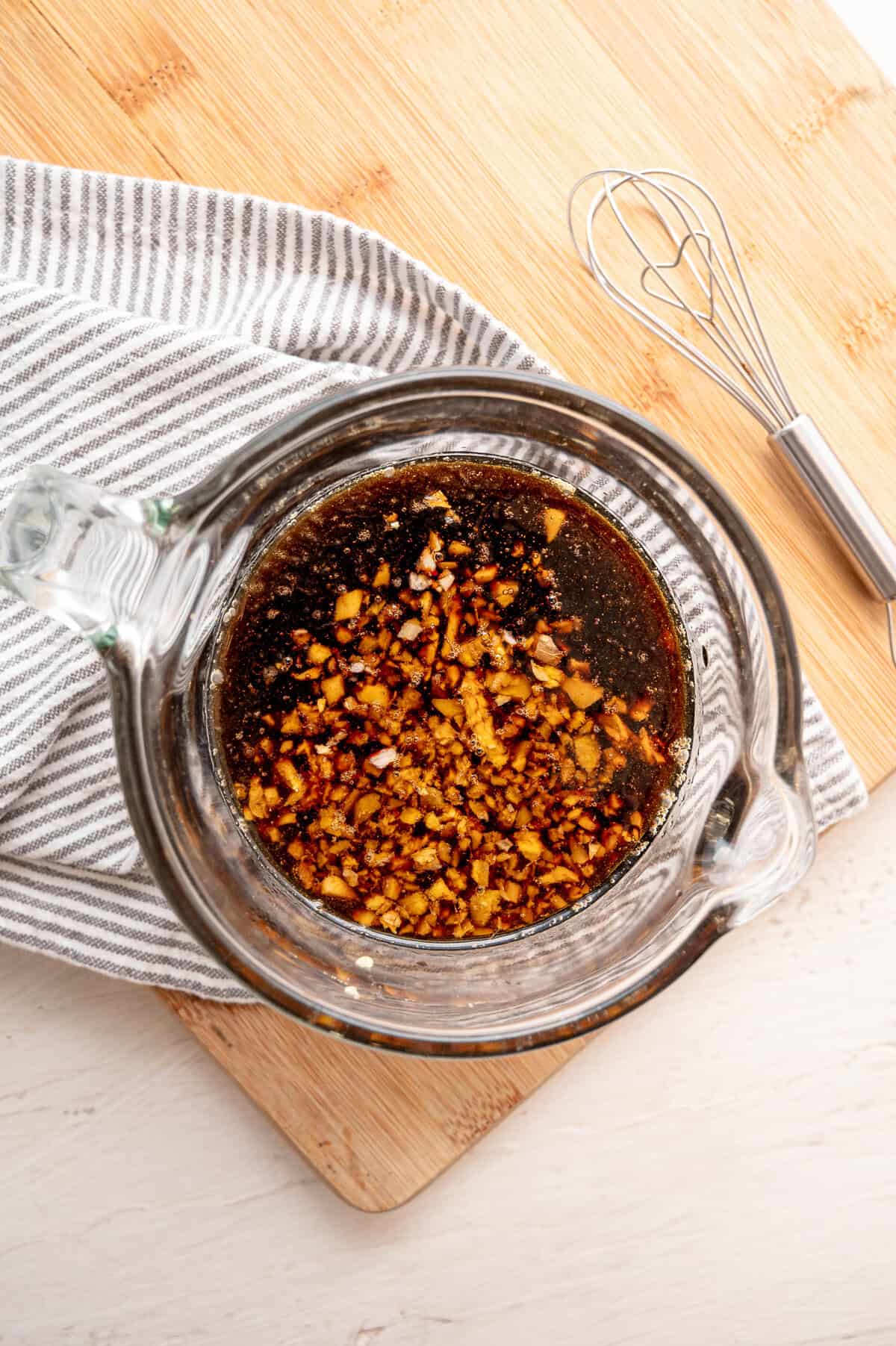 Ingredients for Korean beef sauce in a small glass mixing bowl with a whisk.